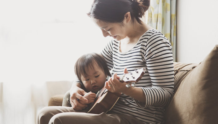 Mother and son playing with a ukelele