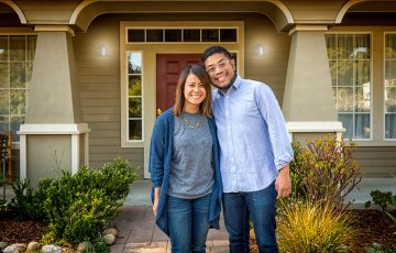 happy couple in front of new home